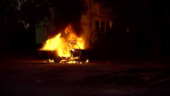 Burning Car Close to a House in a Sleeping Area of City