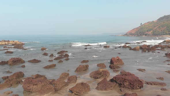 Fly over small beach rocks, serene and quiet Arambol beach, Goa, India.  