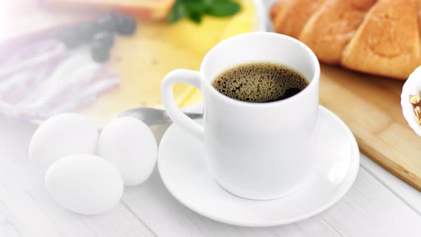 Closeup Cup Aromatic Black Coffee and Appetizing Tasty Breakfast Meal Surrounded By Natural Light