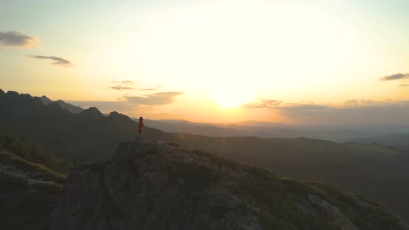 Adventurous Man Climbing Mountain Peak at Sunset