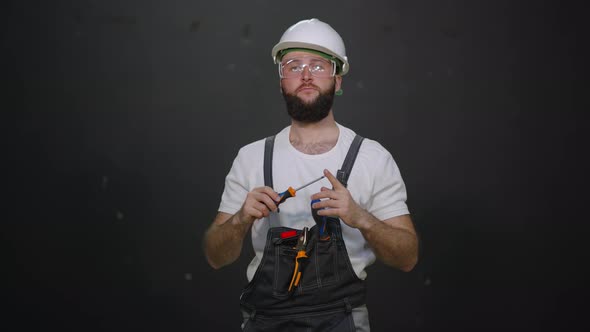 Portrait of a Worker with Tools Wearing Overall and Helmet