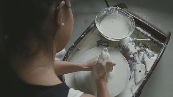 Moulding a clay pot on pottery wheel