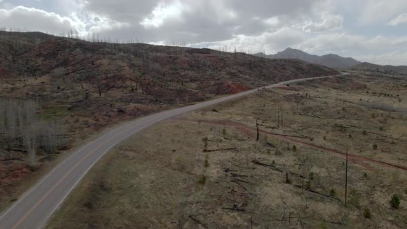 Aerial view panning across a remote mountain road in the Pike National Forest, Rocky Mountains.  Col