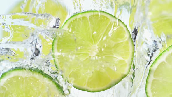 Water splash on sliced lime. Slow Motion. alt
