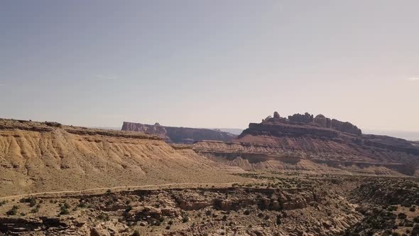 Incredible beautiful drone footage flying towardsd mesa rock over desert valley, bushes and landscap