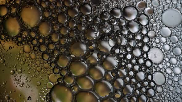 Bubbles popping in liquid mixture of water and oil