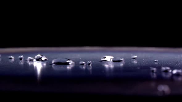 Water droplets bouncing on shinny surface.