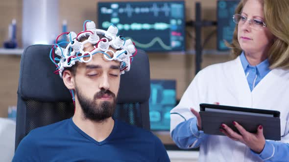 Male Patient with Eyes Closed While Doctor Checking Brain Activity