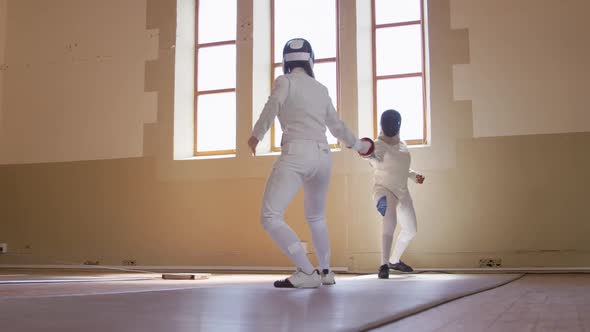 Fencer athletes during a fencing training in a gym