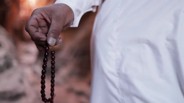 Muslim hand holding and counting prayer beads in slow-motion