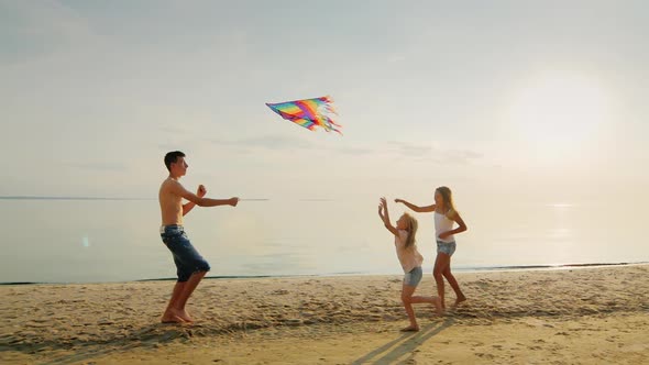 Carefree Children Play Together. The Elder Brother Entertains Younger Sisters Kite