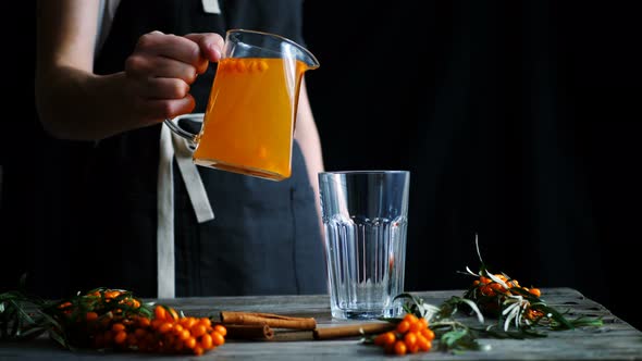 Herbal Sea Buckthorn Tea Glass Pouring From Teapot with Herbal Into the Glass