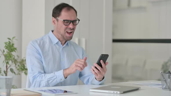 Upset Middle Aged Man Reacting to Loss on Smartphone