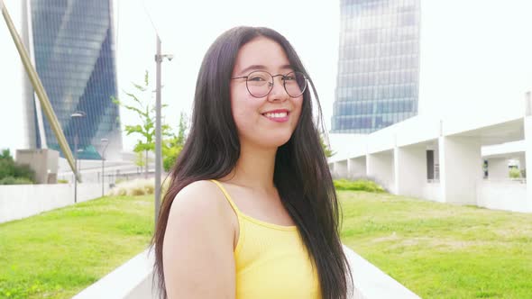 portrait of young asiatic friendly woman posing outdoor smiling