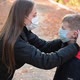 Woman Putting a Face Mask on Her Child Outdoors - VideoHive Item for Sale