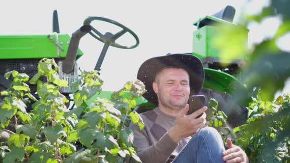 Happy Farmer Uses a Smartphone He Has Fun Laughing