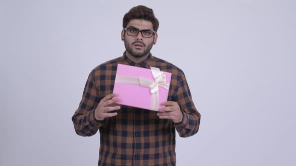 Happy Young Bearded Indian Hipster Man Shaking Gift Box