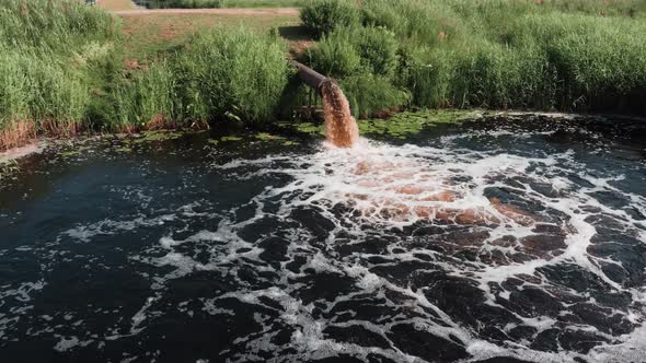 Dirty sewage is pouring from the pipe, industrial waste, man-made pollution of the environment.