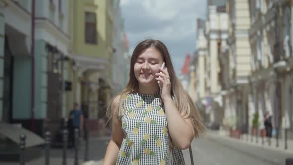 Adorable Young Woman Talking By Cell Phone Walking Through City Street