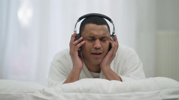 Portrait of Happy Relaxed Carefree African American Young Man in Headphones Enjoying Music Singing