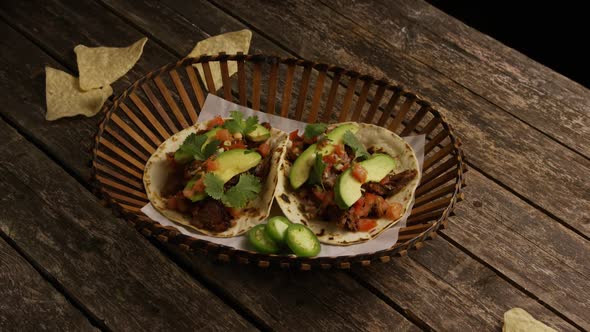 Rotating shot of delicious tacos on a wooden surface