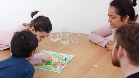 Mixed Family Playing with Board Game Together at the Table