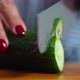 Women cuts a cucumber with a knife - VideoHive Item for Sale