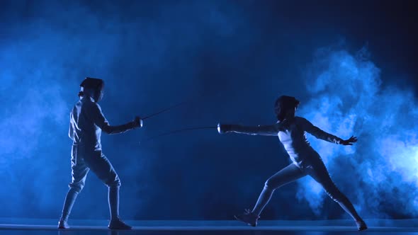 Two Female Athletes Train on Foil at Fencing Tournament