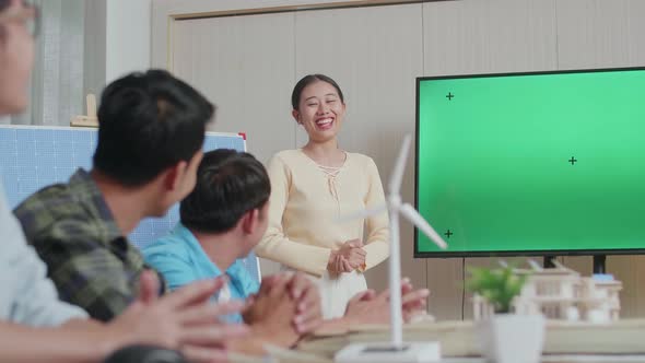 Asian Woman Engineer With Solar Cell Presenting About The Green Screen Tv At The Office