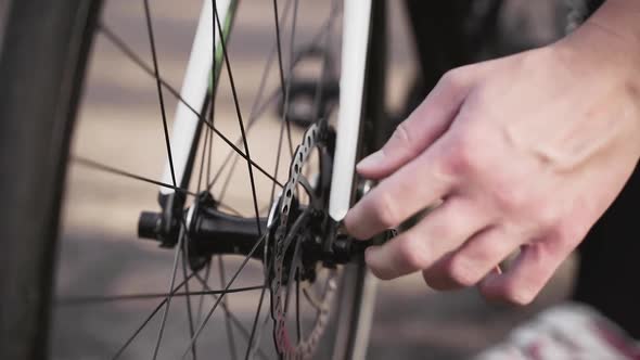 Hands of cyclist removing front wheel from bicycle