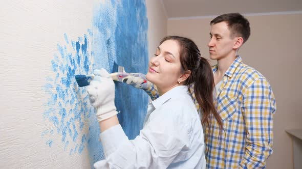 Young Designers Lady and Man in White Gloves Draw on Wall