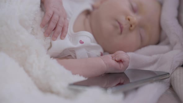 Smartphone Lying in Bed with Sleeping Caucasian Infant Child