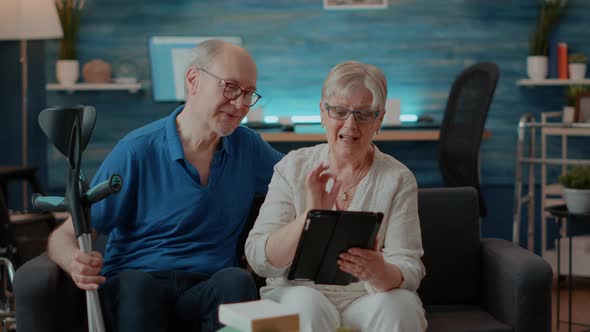 Senior Couple Waving at Tablet Webcam on Online Video Call