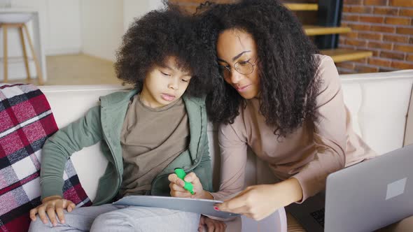 African American Mother and Son are Drawing While Using Laptop