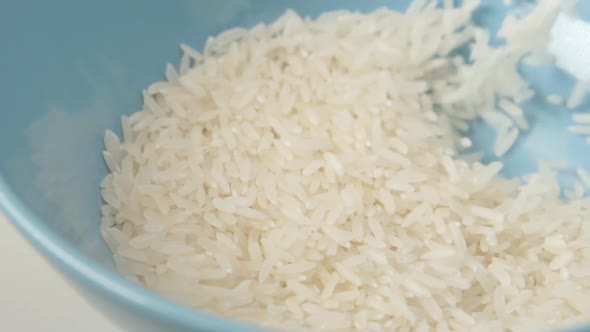 White Rice Fall On Blue Dish