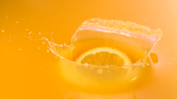 Sliced orange falling into orange juice, Slow Motion alt