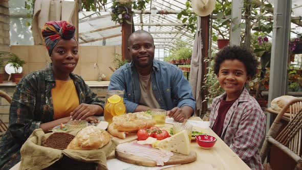 Portrait of Happy Afro-American Family at Dinner in Greenhouse