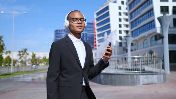 Dancing Businessman Using Smartphone In Wireless Headphones