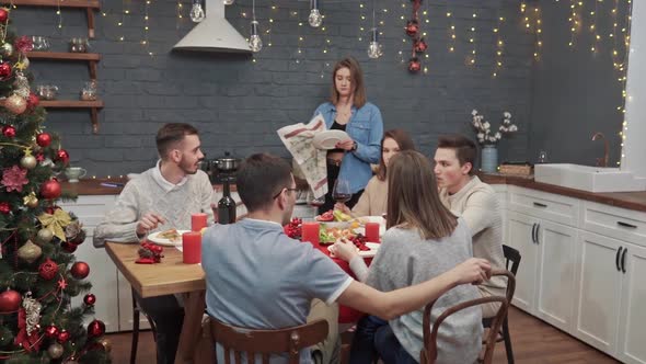 A Girl Puts a Plate on the Table for Those Sitting Outside at the Dining Table Set for a Family Meal