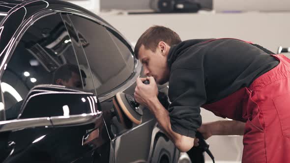 Man Polishing a Black New Car