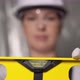 Woman Builder in Blue Overalls and White Hard Hat Helmet with Level - VideoHive Item for Sale