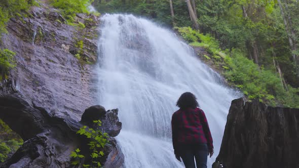 Woman Watching the Waterfall in the Canadian Rainforest