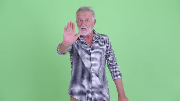 Serious Senior Bearded Man Showing Stop Gesture