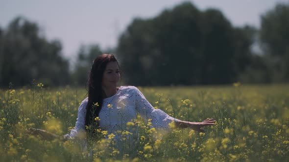 Pretty young woman in the rapeseed field