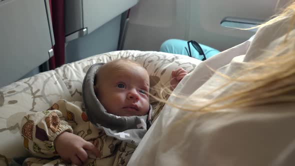 Three Month Baby Girl Smiling and Looking at Mother During the Flight