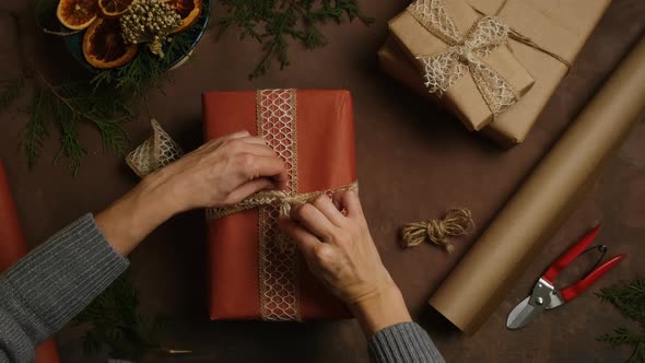 Woman Tie a Bow on Box with Christmas Present