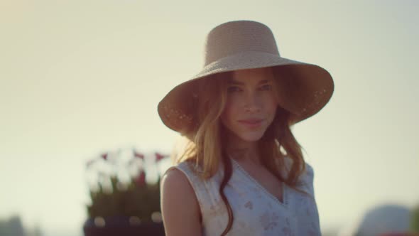 Sensual Blonde Woman in Sunhat Looking at Camera in Bright Summer Day Outside