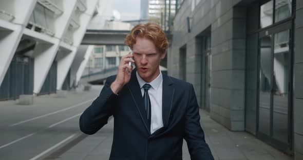 Confident Handsome Businessman in Formal Suit Emotionally Talking By Mobile Phone While Standing