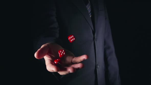Businessman Throws Up And Catches A Few Playing Cubes