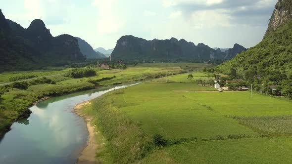 Camera Removes Over Meadows and River with Reflected Clouds